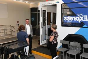 Three people talking in a room with rehabilitation equipment